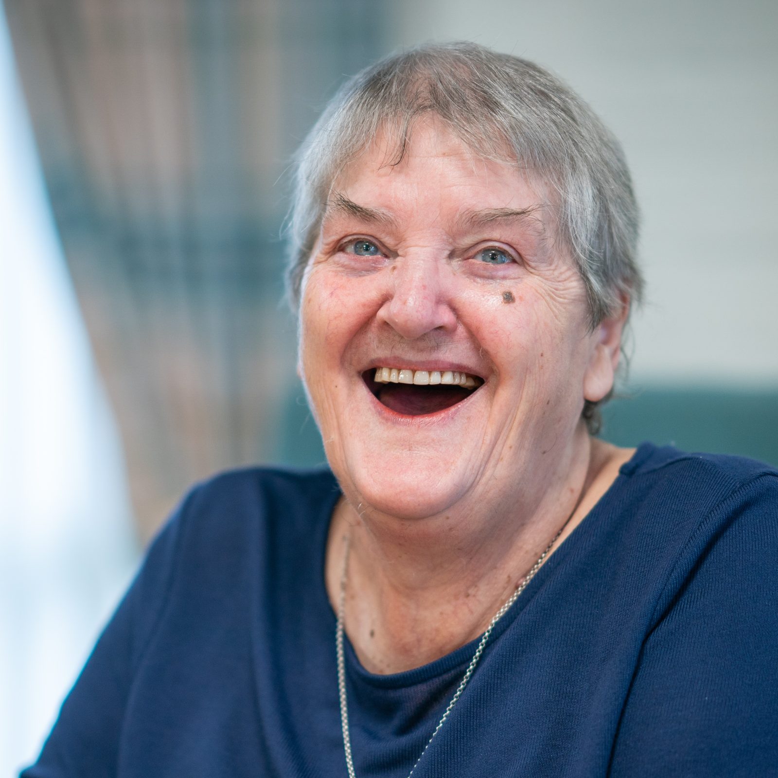 Joyful senior woman with a heartfelt laugh sharing a moment of happiness.