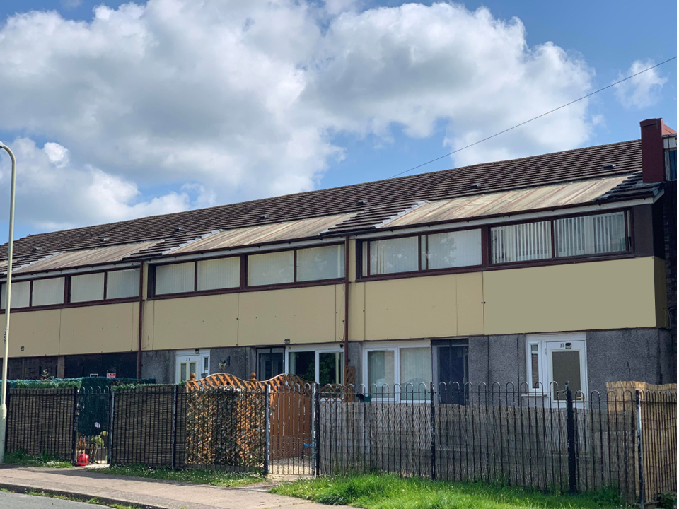 Trivallis Housing Landlord Wales A row of two-story terraced houses is depicted under a partly cloudy sky. The houses feature a consistent architectural style with predominantly brown and beige exterior walls. Each house has a front yard, some of which have fences and small plants.