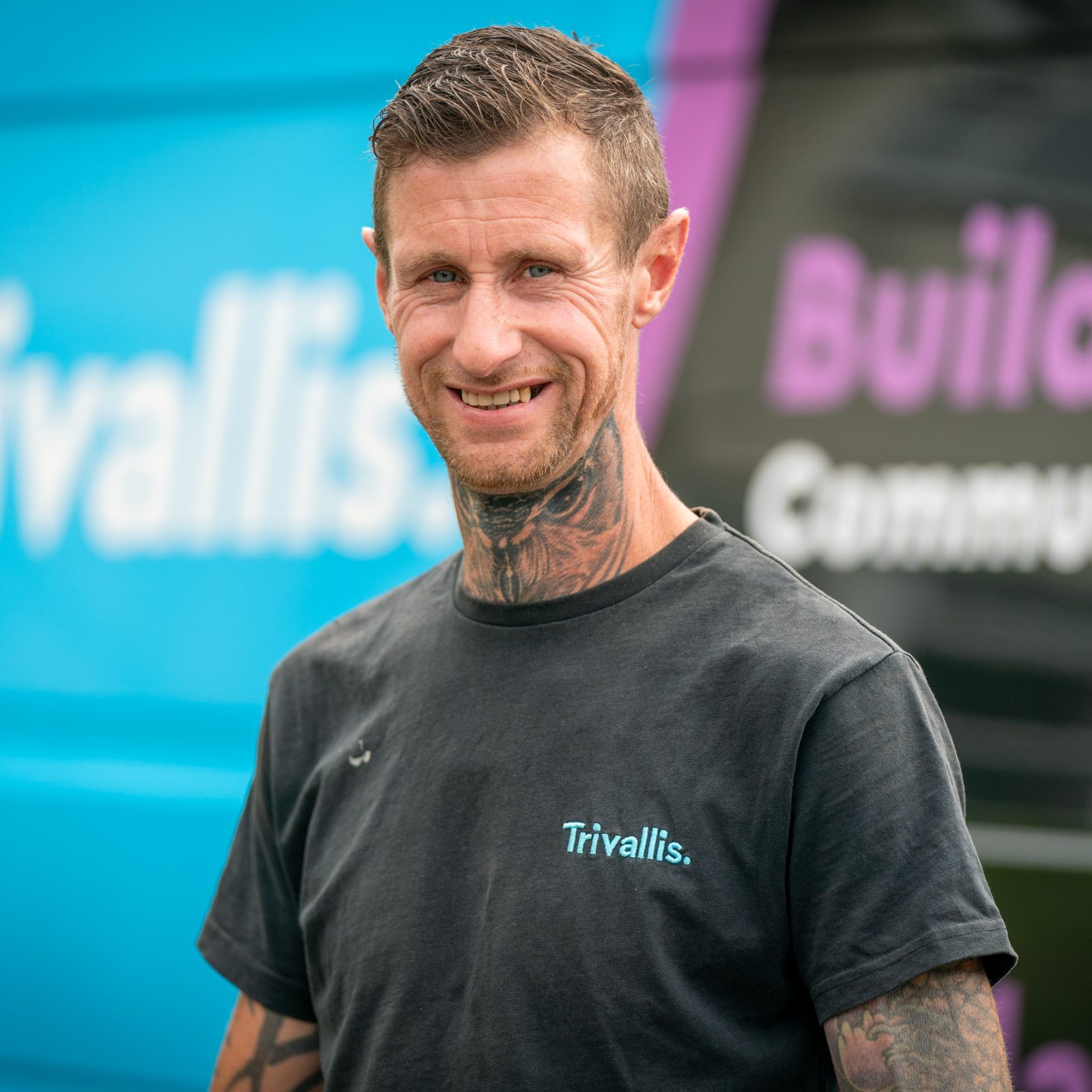 Trivallis Housing Landlord Wales A man with tattoos on his neck and arms wears a black 